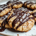 Biscuits noix de coco sans gluten : croustillants et faciles à faire 5 biscuits noix de coco sans gluten dorés sur assiette en bois