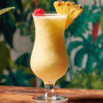 Recette Piña Colada sans gluten facile et rapide à préparer chez soi 5 Recette Piña Colada sans gluten présentée sur une table tropicale