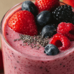 smoothie aux fruits rouges dans un verre sur table rustique